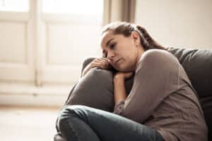 a person leans against a couch while recognizing high functioning depression