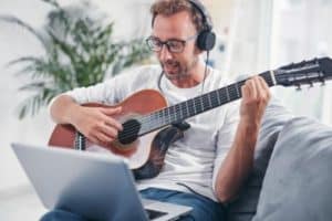 a man practices guitar during a music therapy program