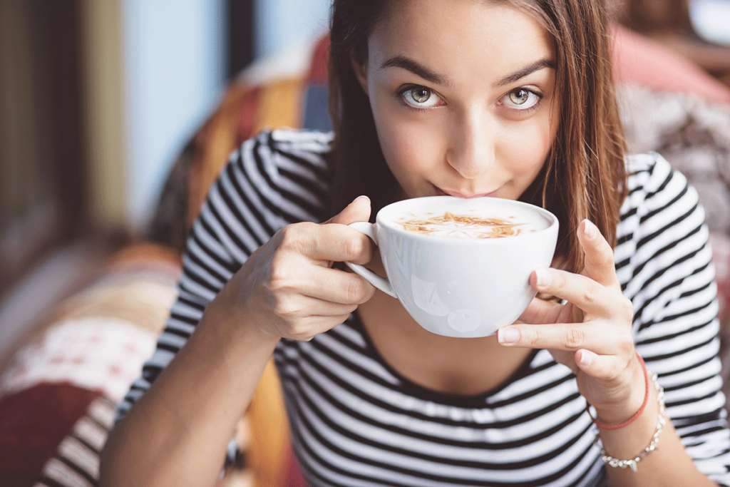 a young woman enjoys a coffee after overcoming her alcohol withdrawal symptoms naturally