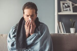 a person blows their nose and wonders how marijuana weakens the immune system