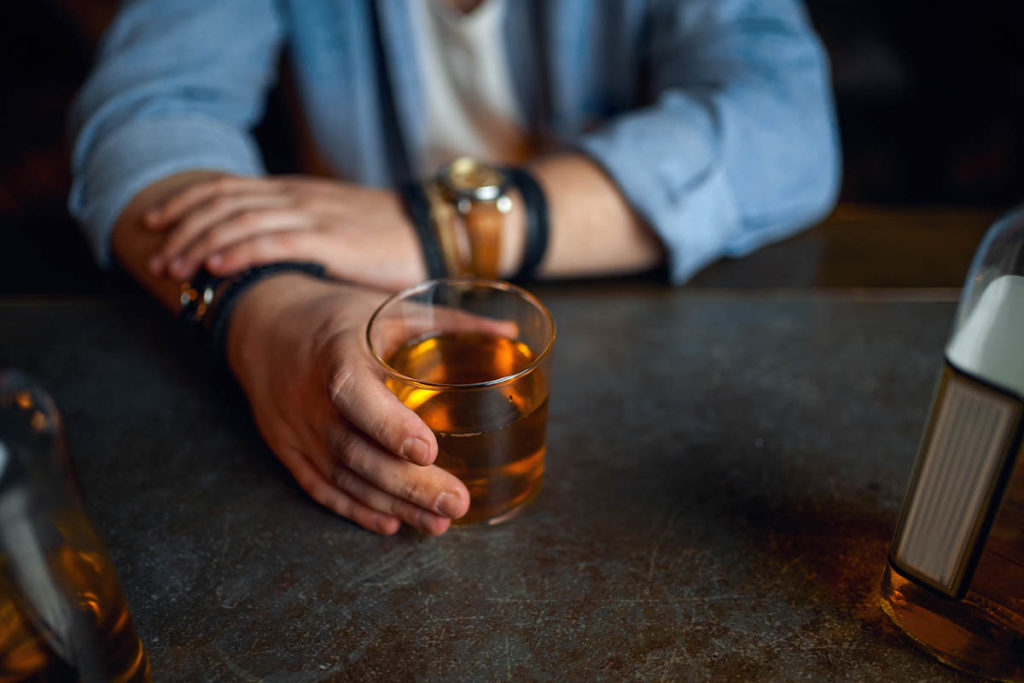 a person drinking a glass possibly dealing with the link between Alcohol and appetite loss