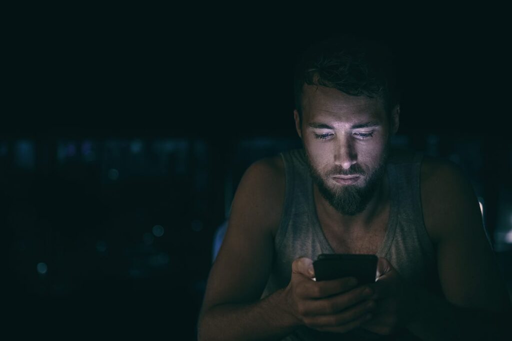 a person looking at their phone in the dark searching for common fentanyl street names
