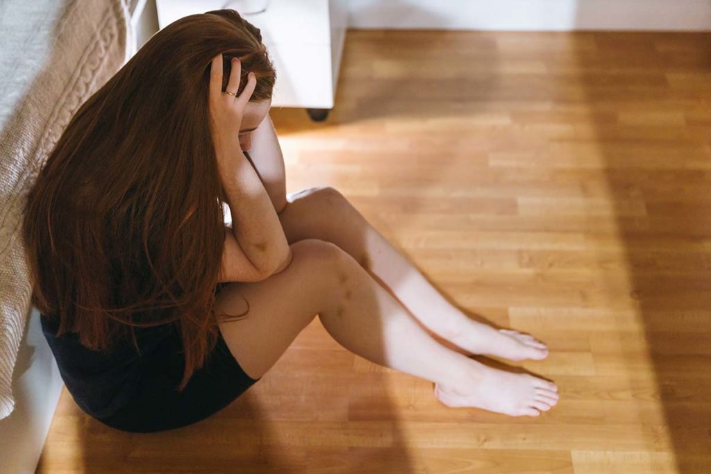 a person sitting on the floor with their head in their hands, anxious and learning about Mental health and substance abuse