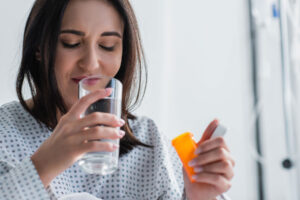 a person taking a pill while drinking a glass of water wonders why is oxycodone addictive