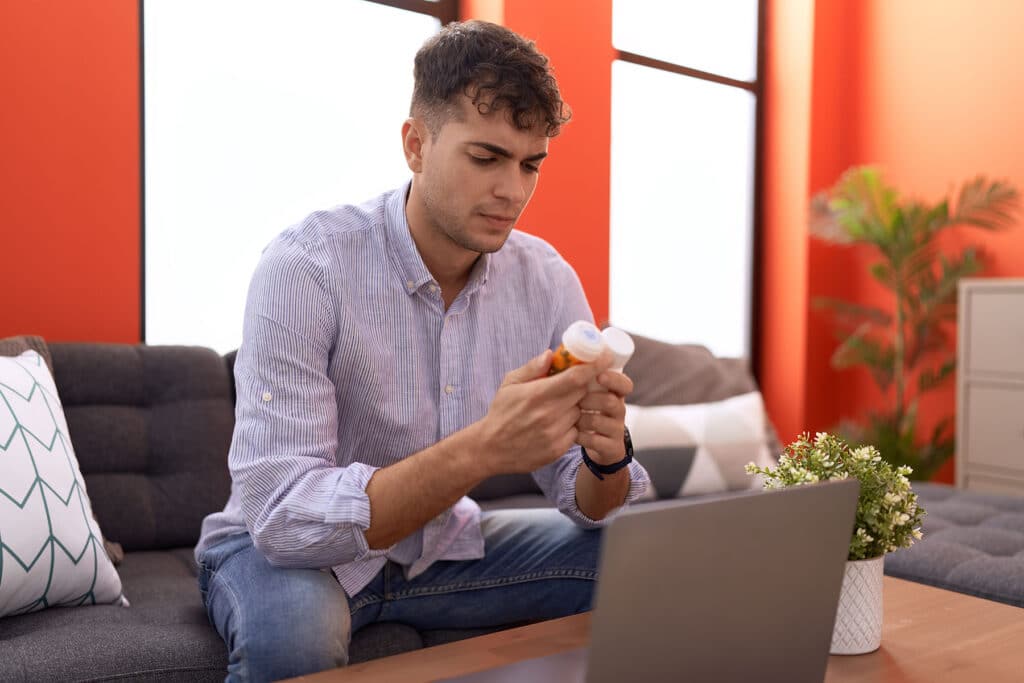 a person looks at a bottle of pills wondering why using xanax for opiate withdrawal