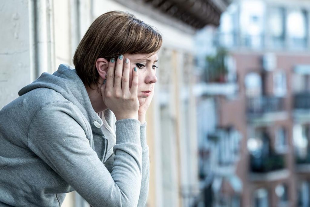 a person leans on a balcony sadly after learning about theside effects of xanax abuse