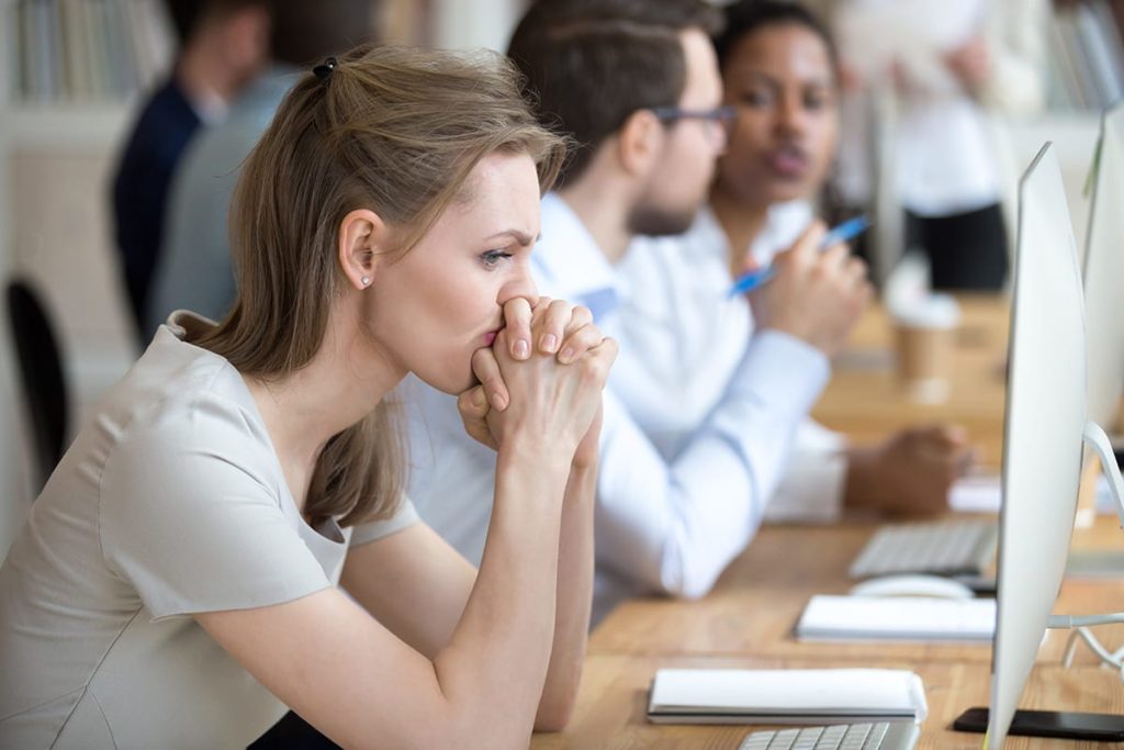 a person sits at a desk at work looking agitated as they suffer a substance abuse problem