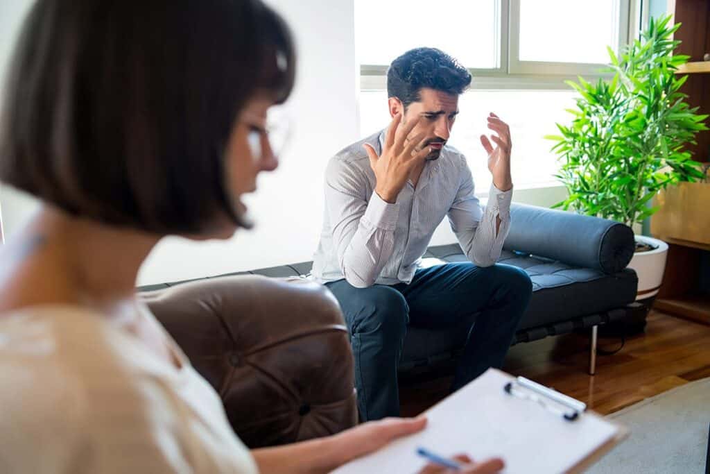 a person talks in therapy while sitting on a couch to overcome oxycontin addiction