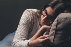 a person lays in a chair looking sad while struggling with the long term effects of cocaine use