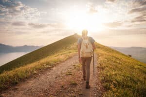 a person hikes during sunset to show the benefits of nature for mental health