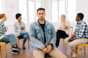 a person focuses on the camera while participating in group therapy activities