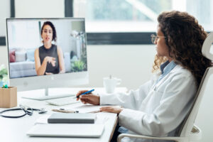 a doctor talks to someone on a computer screen about the benefits of a virtual outpatient program