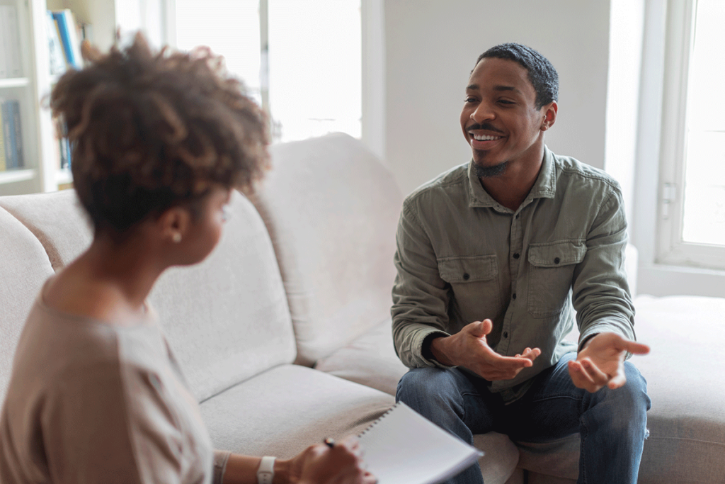 a patient looks happy sitting on a chair talking to a therapist after finding a marijuana treatment program in loveland co