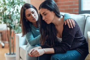 a friend comforts a friend showing signs of prescription drug abuse in a friend