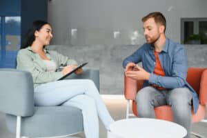 two people talk sitting in chairs after finding a residential treatment center in loveland co